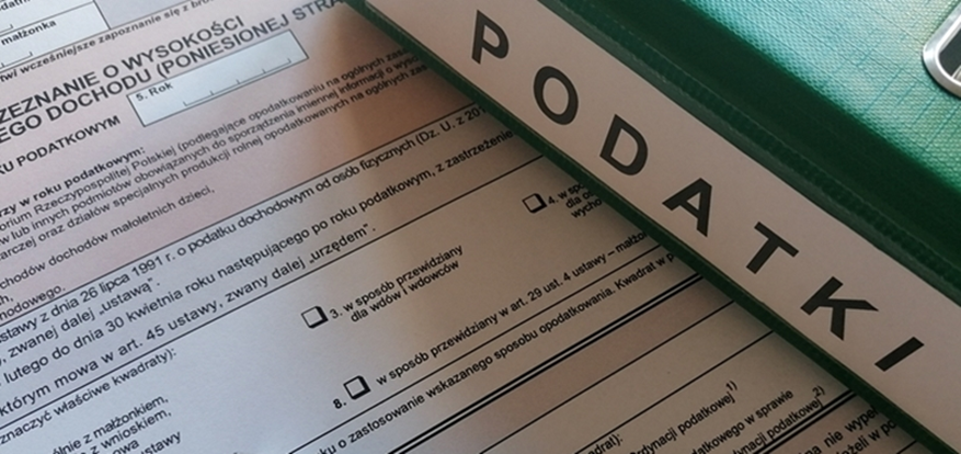Formularz podatkowy oraz segregator z napisem podatki  