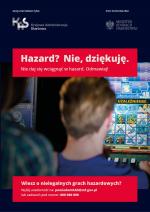 Młody mężczyzna w niebieskiej bluzie i krótkich blond włosach gra na automacie w grę hazardową. Na automacie widnieje napis 