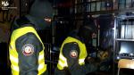 w ciemnym pomieszczeniu dwóch funkcjonariuszy Służby Celno-Skarbowej stoi przed karatami jest automat do gry, jeden z funkcjonariuszy trzyma w dłoniach szlifierkę, którą będzie ciał kratę.
