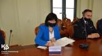 przy stole siedzi Dyrektor Izby Administracji Skarbowej w Opolu i popisuje dokument