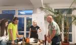 Kobieta i mężczyzna pochylają się nad stolikiem, na którym ustawione są okazy Cites. Obok przedstawicielka KAS i funkcjonariusz. Z tyłu ekran z prezentacją.