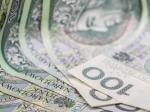 rozłożone na stole banknoty 100 zł