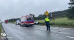 Ulica. Funkcjonariusz KAS stoi  i zatrzymuje pojazdy. Z tyłu ambulans i pojazd KAS.