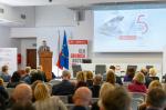 Sala konferencyjna. Uczestnicy konferencji siedzą i słuchają dyskusji. Przed nimi uczestnicy panelu dyskusyjnego.