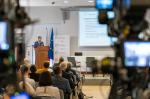 Sala konferencyjna. Uczestnicy konferencji siedzą i słuchają dyskusji. Przed nimi uczestnicy panelu dyskusyjnego.