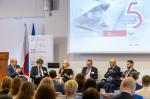 Sala konferencyjna. Uczestnicy konferencji siedzą i słuchają dyskusji. Przed nimi uczestnicy panelu dyskusyjnego.