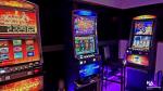 w przyciemnionym pomieszczeniu znajdują się trzy automaty do gier hazardowych 