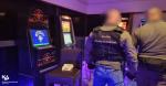 Salon gier. W nim 4 automaty i stojący 2 funkcjonariusze.