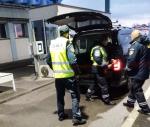 funkcjonariusze z Rumunii i Polski wspólnie kontrolują samochód na przejściu granicznym