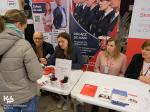 Pracownicy opolskiej Krajowej Administracji Skarbowej rozmawiają przy stanowisku z uczestniczką targów pracy.
