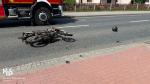 Na jezdni leży uszkodzony motocykl.