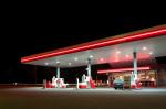 Zdjęcie zrobione w nocy, przedstawiające samochód osobowy na stacji benzynowej  