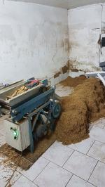 Stosy tytoniu i maszyna do cięcia w pomieszczeniu gospodarczym